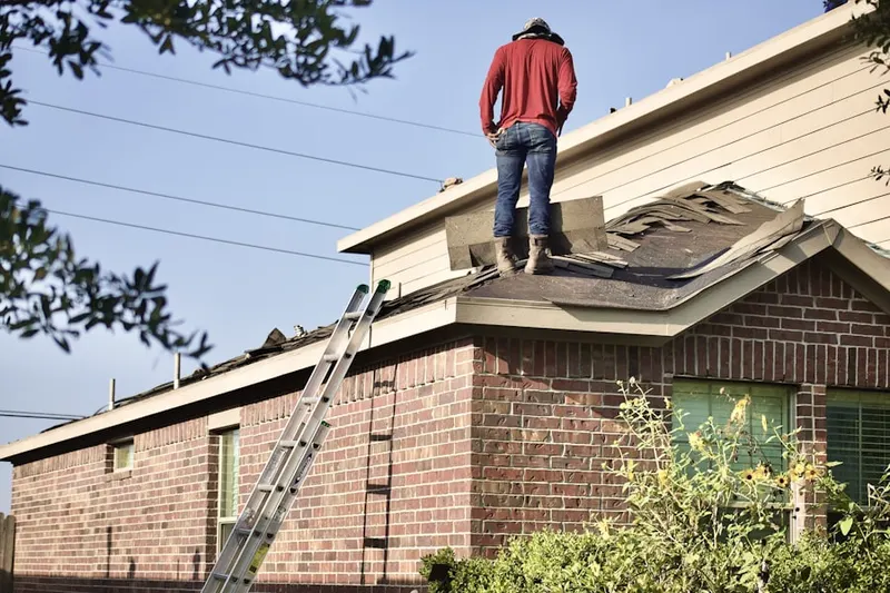 Professional roofer working on a residential roof in Ferris